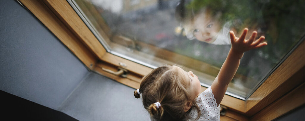 petite fille devant une fenetre